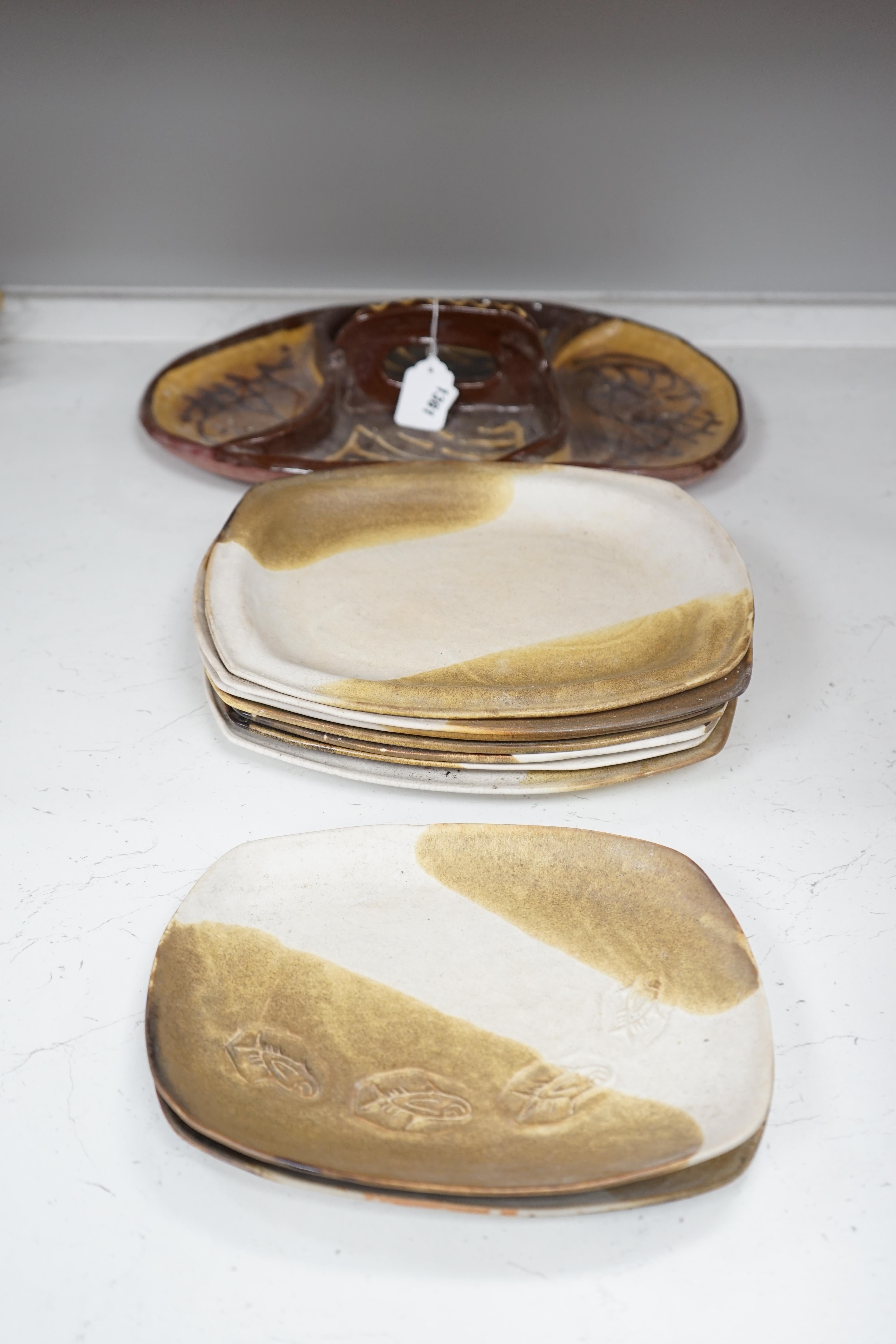 A set of nine studio pottery plates together with a slipware dish, 46cm long